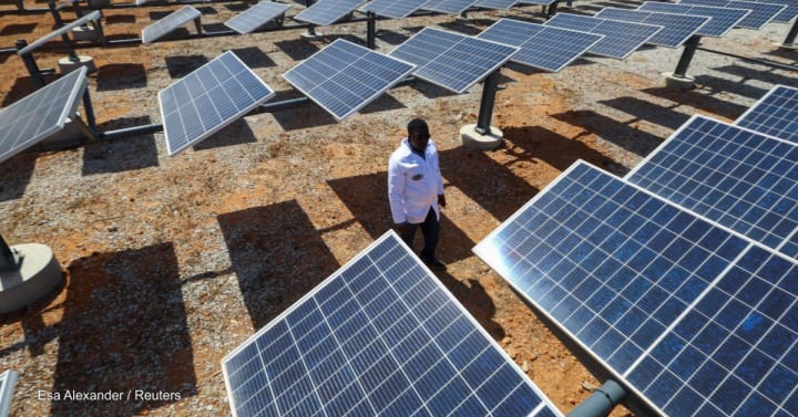 person standing by solar panels